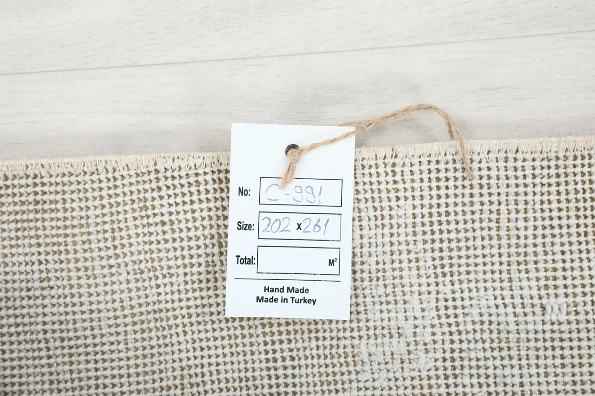 Product tag on the back of the rug, confirming hand-made origin from Turkey and size 202x261 cm.