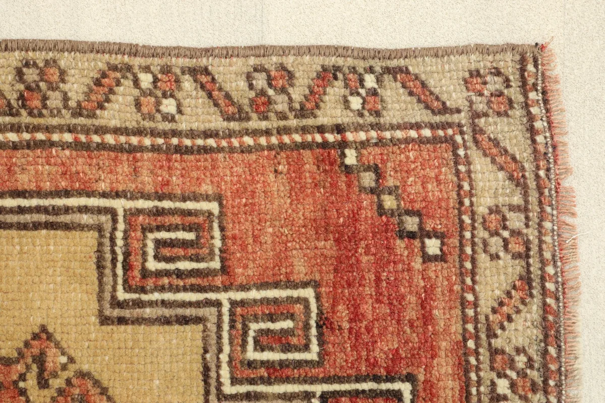 Close-up of the rug's edge, highlighting the low wool pile and the hand-knotted texture.