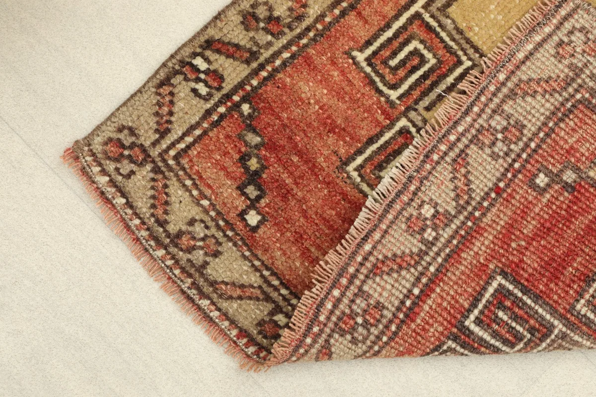 View of the rug folded, showing the thickness of the wool pile and cotton foundation.