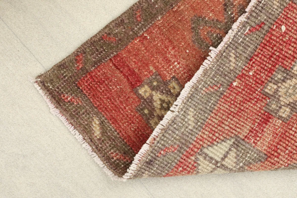 View of the rug folded to show the low pile and reverse side texture.