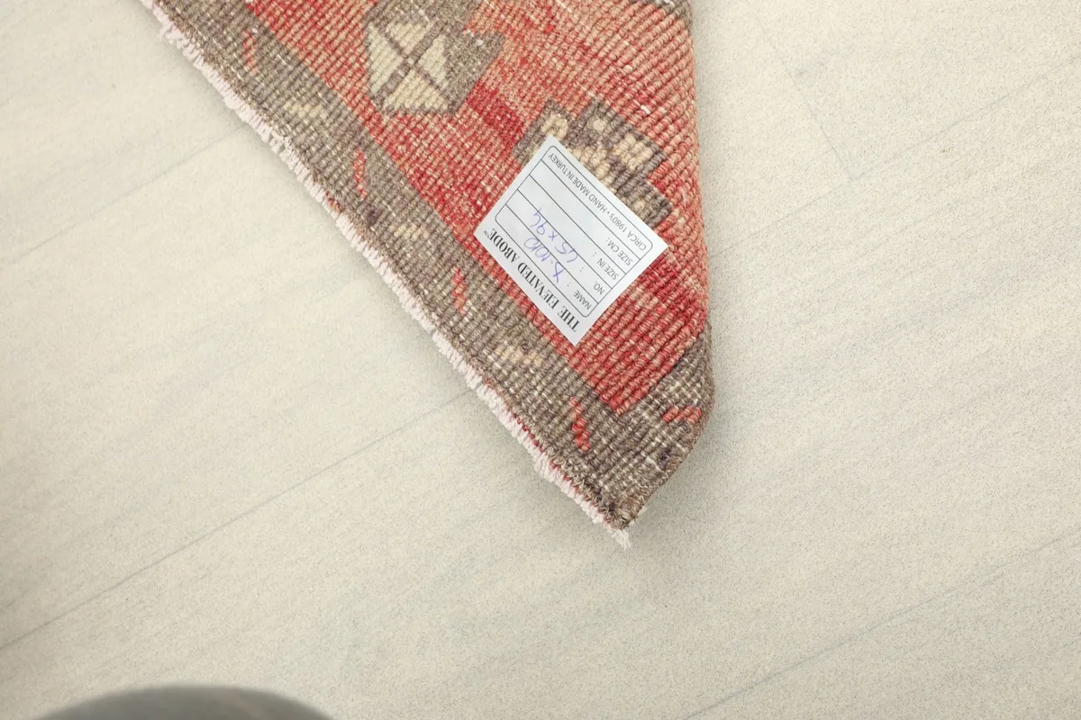 Underside view of a corner of the rug, revealing the hand-knotted cotton foundation.