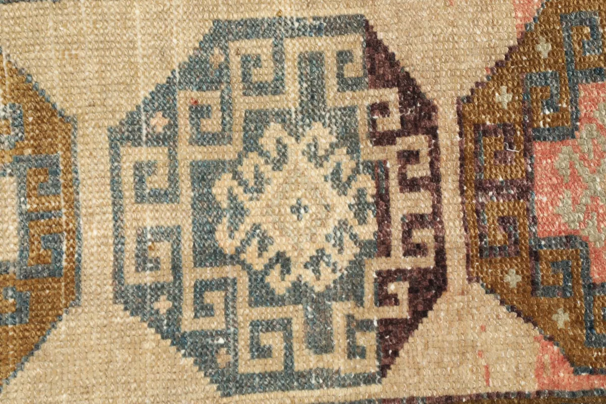 Detailed close-up of the central medallion, showcasing the intricate blue geometric patterns and beige field.