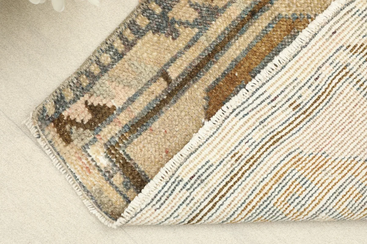 View of the rug's underside, revealing the hand-knotted cotton foundation and wool pile.