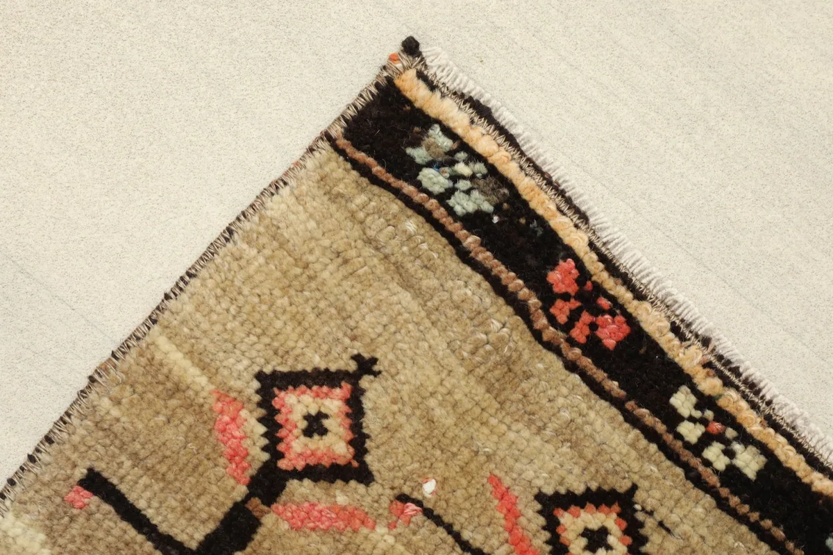 Corner detail showing the black border with small rose, green, and blue floral accents.