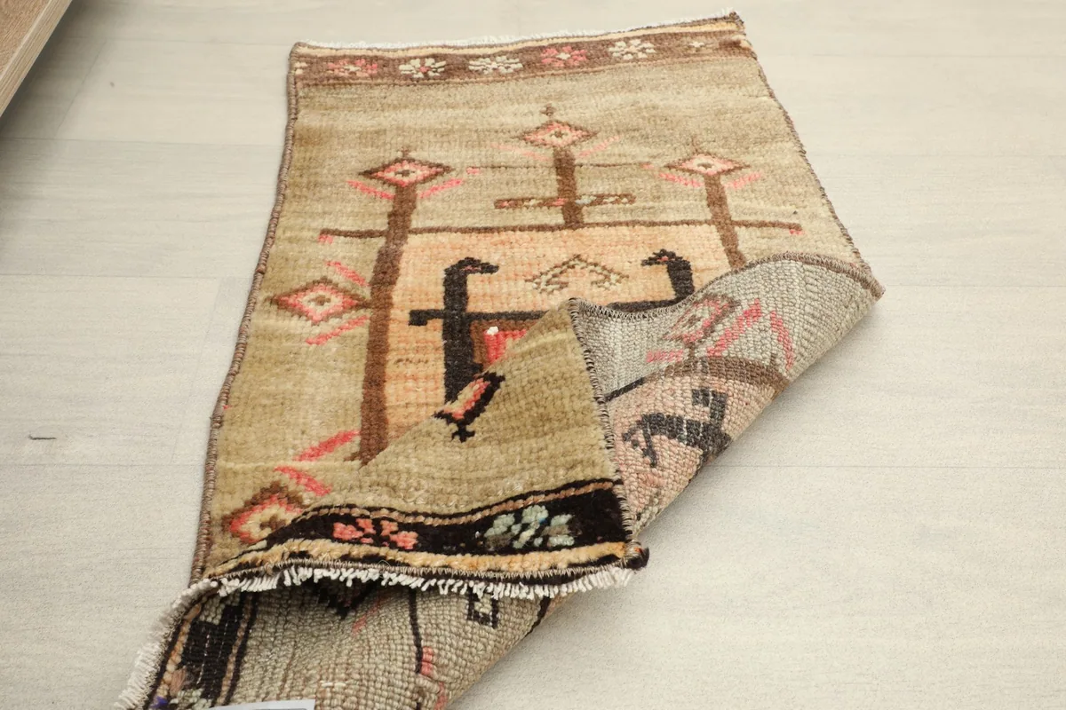 Partial view of the rug's back, indicating the hand-knotted cotton foundation and wool pile.