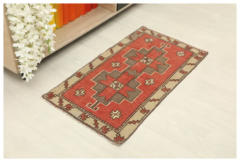 Full top view of the 1'8" x 3'1" vintage Anatolian doormat with red and beige geometric patterns