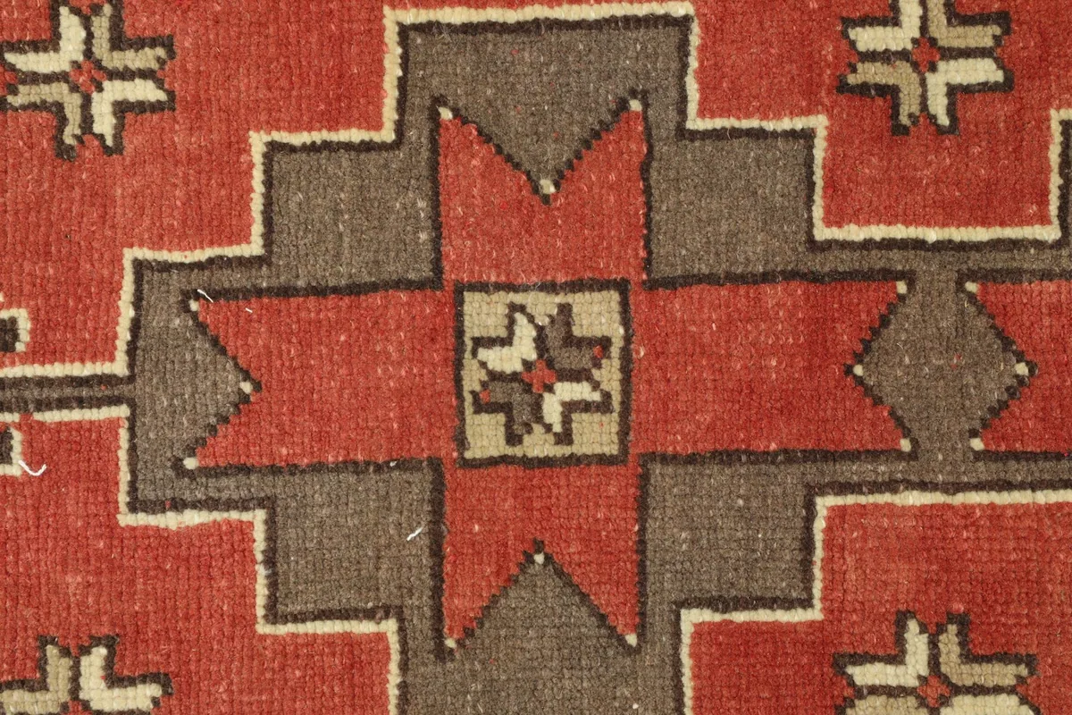Extreme close-up of a central star-like motif in red, brown, and beige