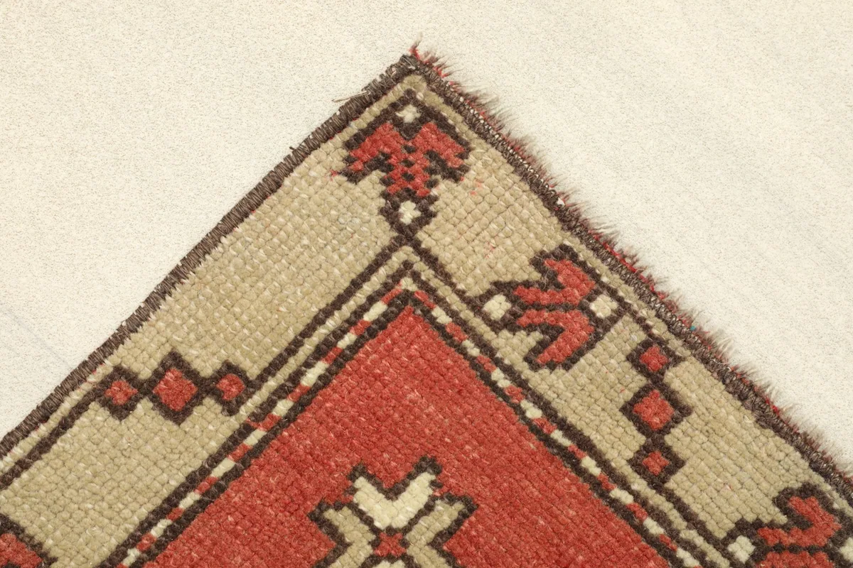 Detailed view of the top left corner, showing the border design and hand-knotted edge