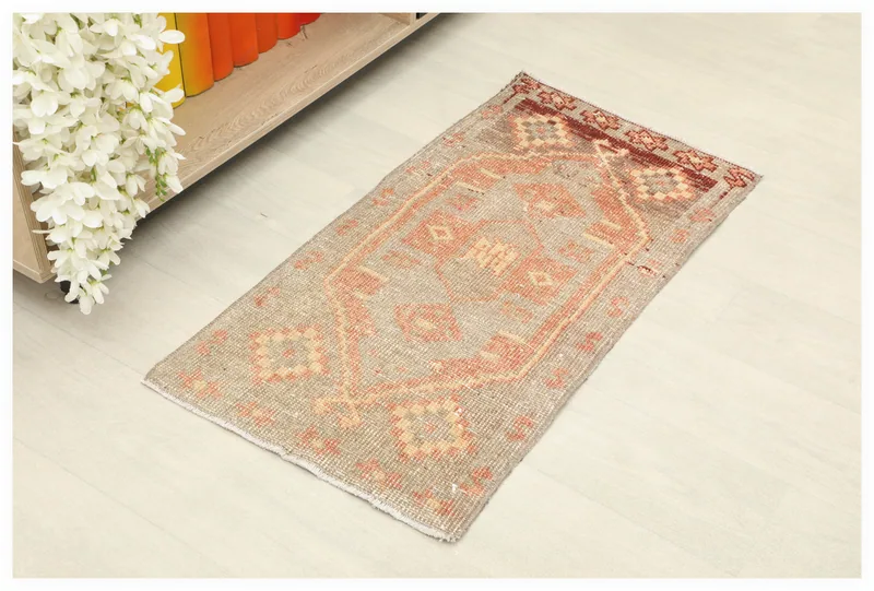 Full overhead view of the beige and rust vintage Anatolian doormat on a white background.