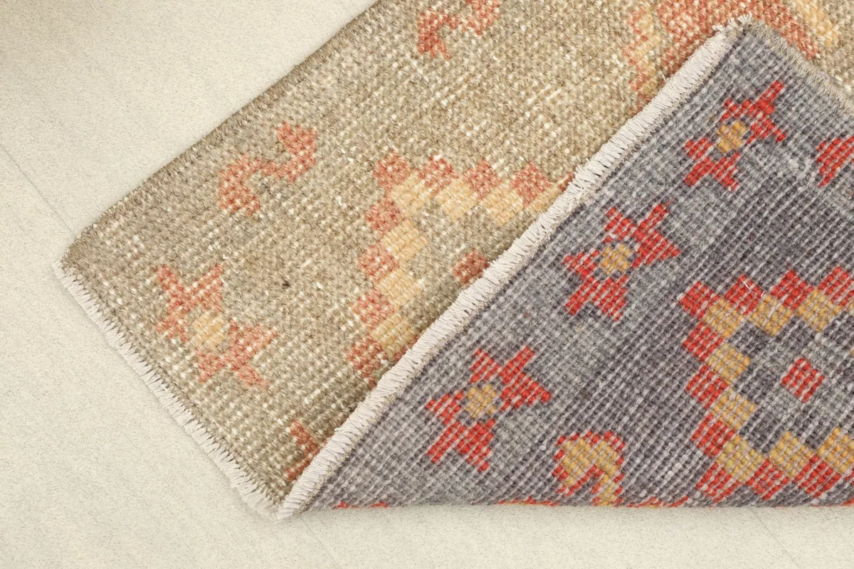 Folded rug showing the front pile and the cotton foundation on the back.