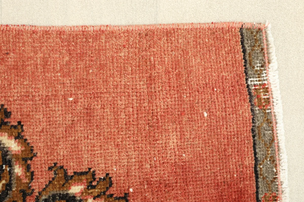 Edge view showcasing the worn fringeless border and the rug's texture