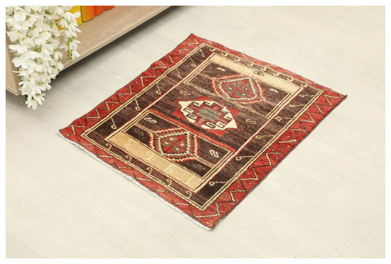 Full top view of the brown and red geometric vintage Anatolian doormat on a white background.