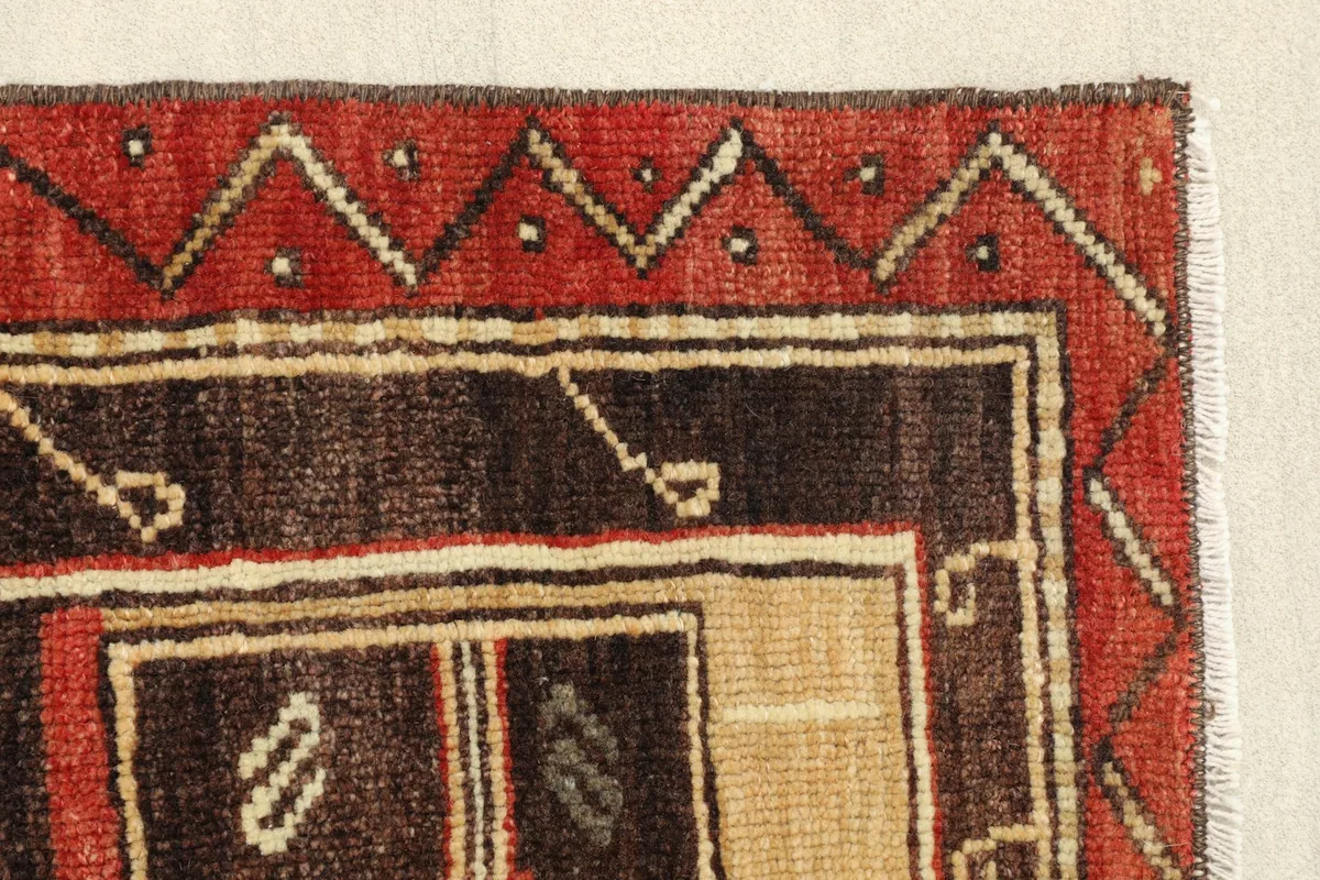 Detail view of the side border and a section of the brown field with small tribal symbols.