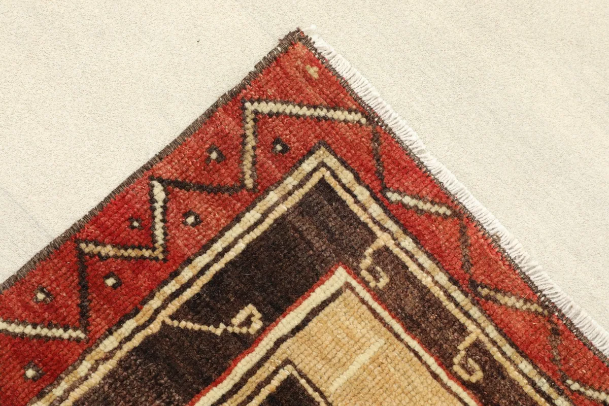 Close-up of the red border with a zigzag pattern and the corner of the rug.