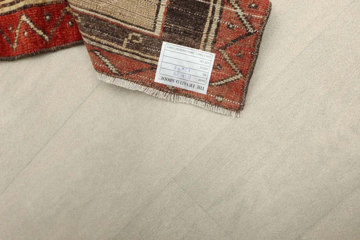 Close-up of the rug's back, showing the hand-knotted structure and a label.