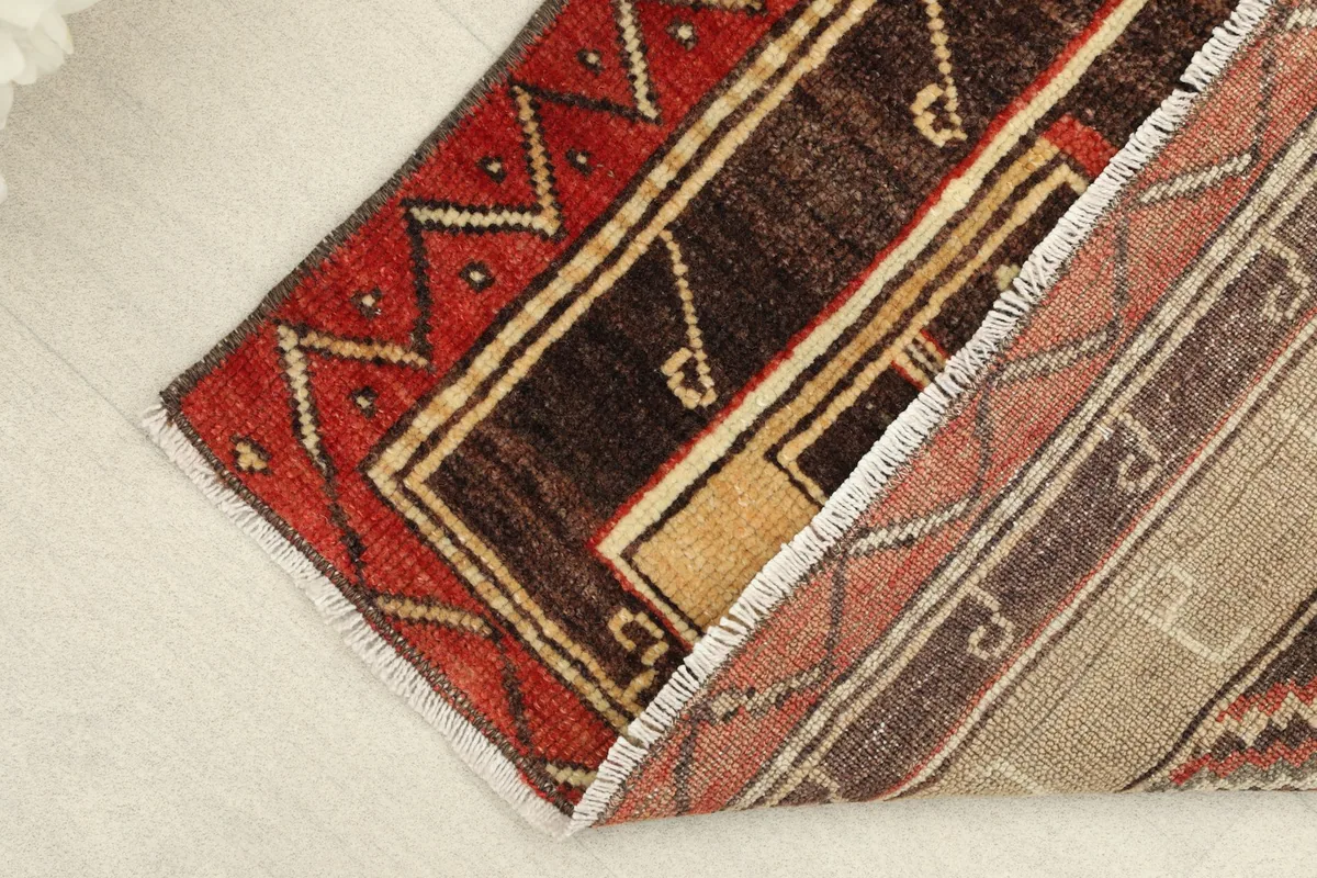 Rug corner folded to show the thickness and the back of the hand-knotted wool pile.