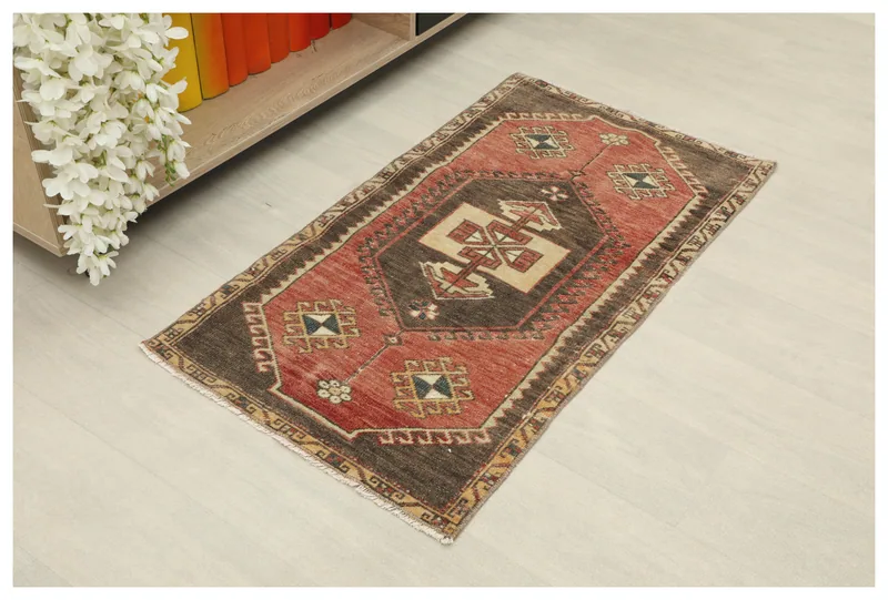 Full top view of the rust and brown geometric Anatolian doormat on a light background