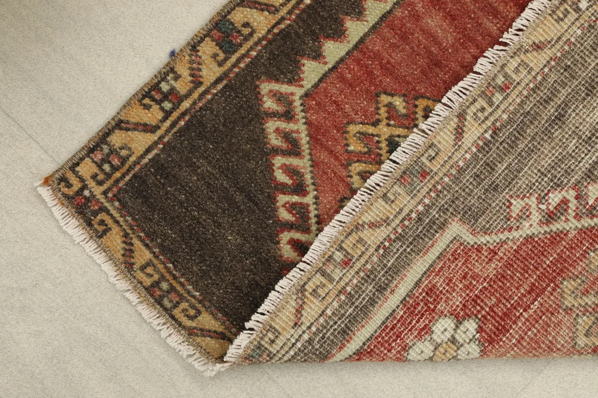 View of the rug's backside and corner, revealing the hand-knotted cotton foundation
