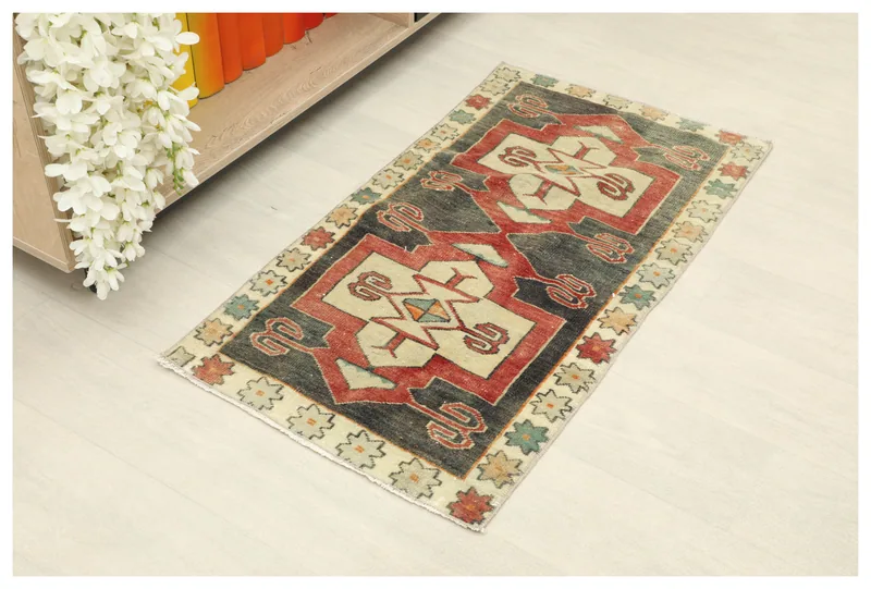 Full top view of the 1'9" x 3'3" charcoal and ivory geometric vintage Anatolian doormat on a white background.