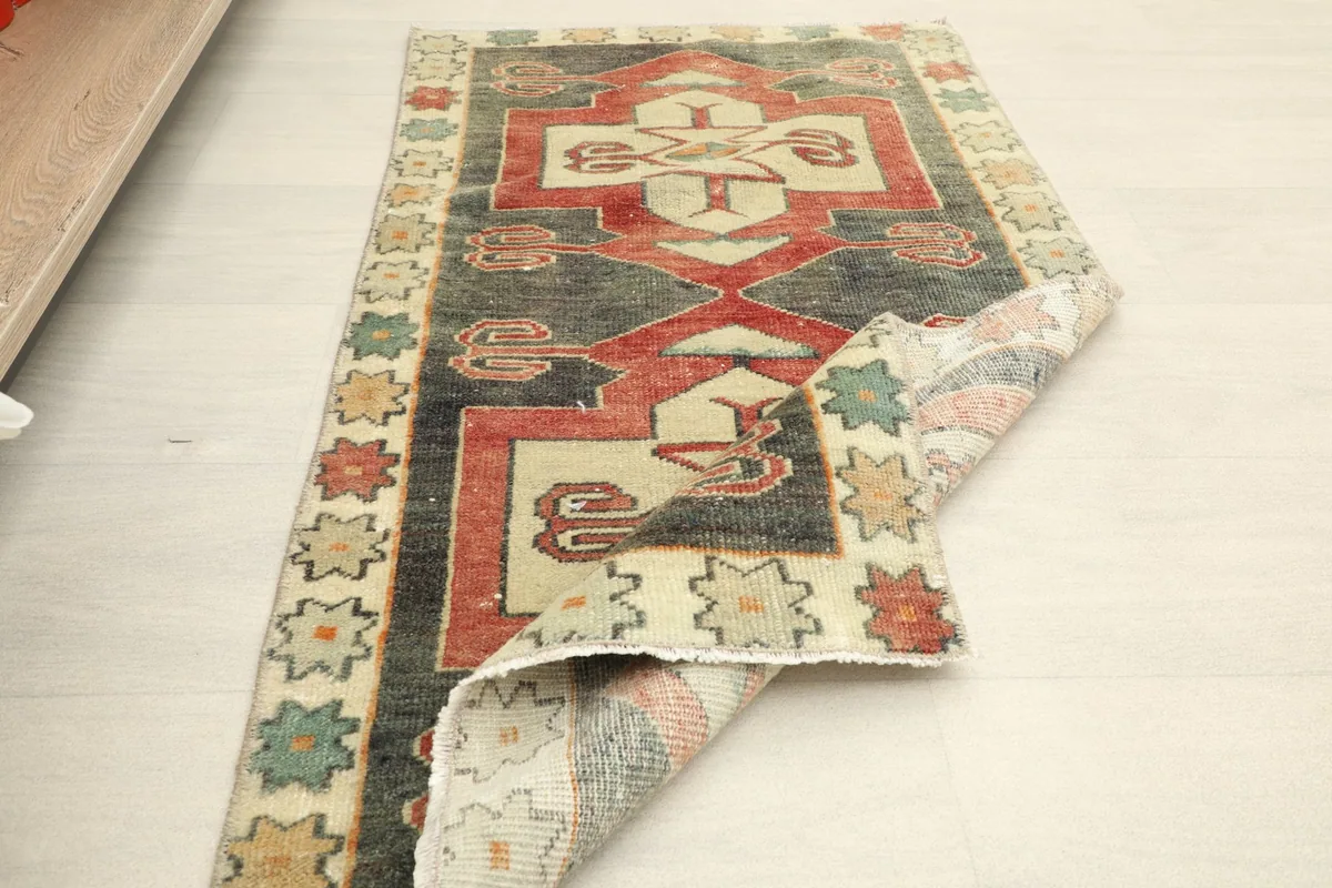 Partial fold of the rug revealing the back and the hand-knotted construction.