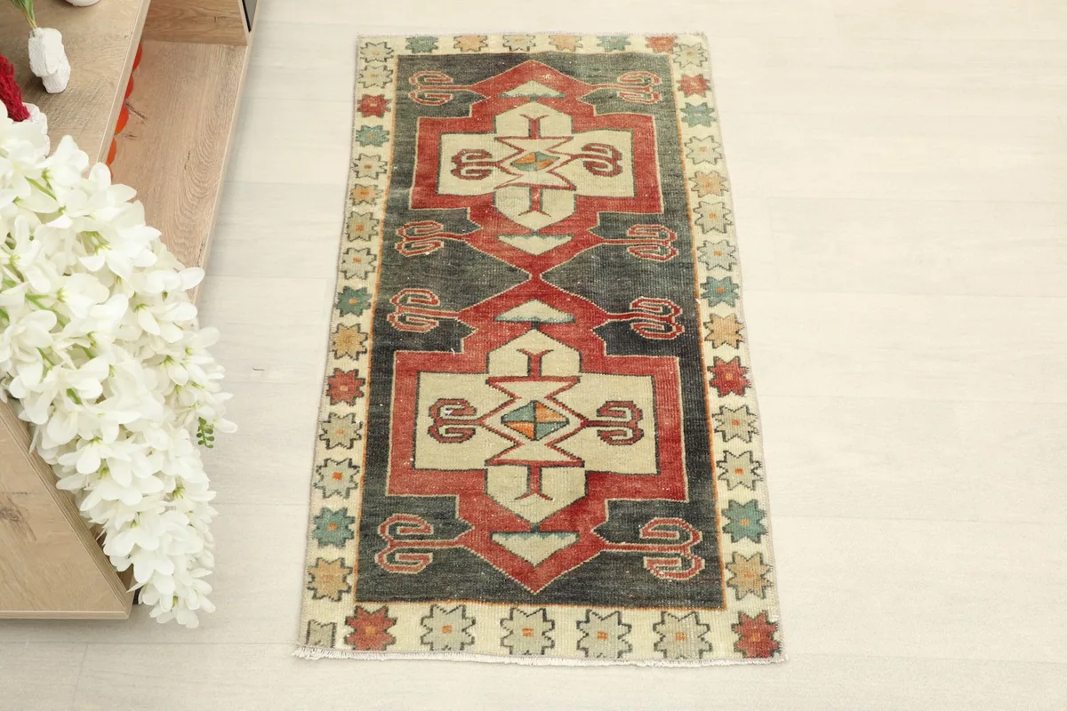 Overhead full view of the hand-knotted charcoal and ivory doormat, showing its geometric patterns.