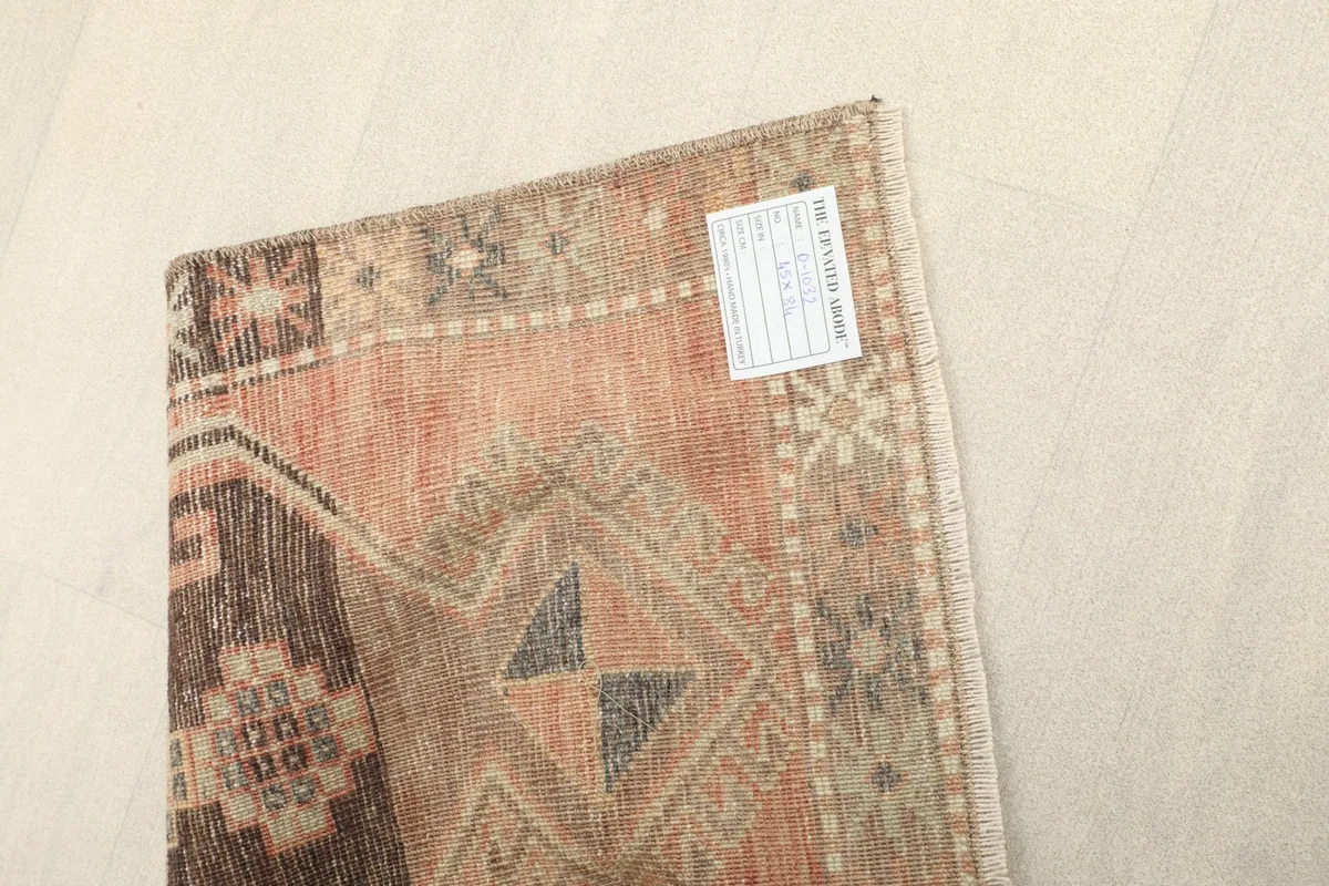 Close-up of the back of the rug, showing the hand-knotted construction and label