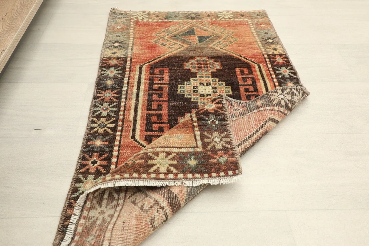Rug partially folded, showing the full design from an angle and the texture of the pile