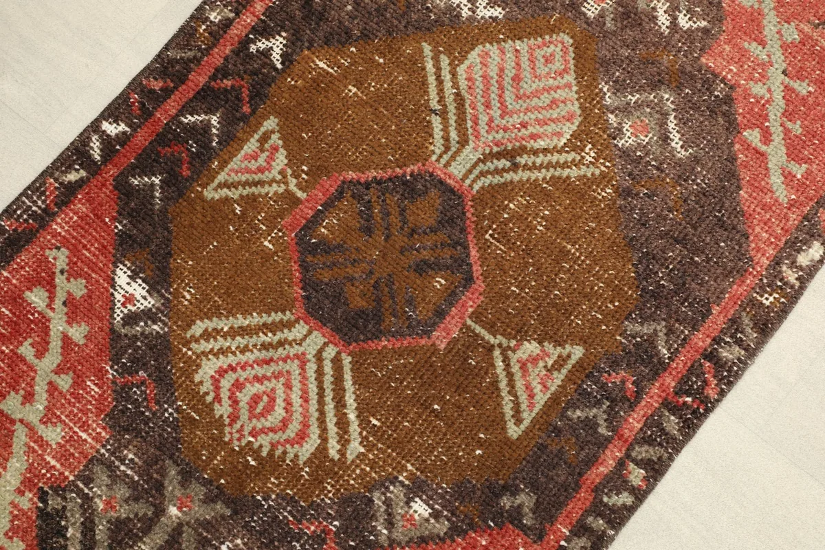 Close-up detail of the central brown geometric medallion and surrounding rust and beige motifs.