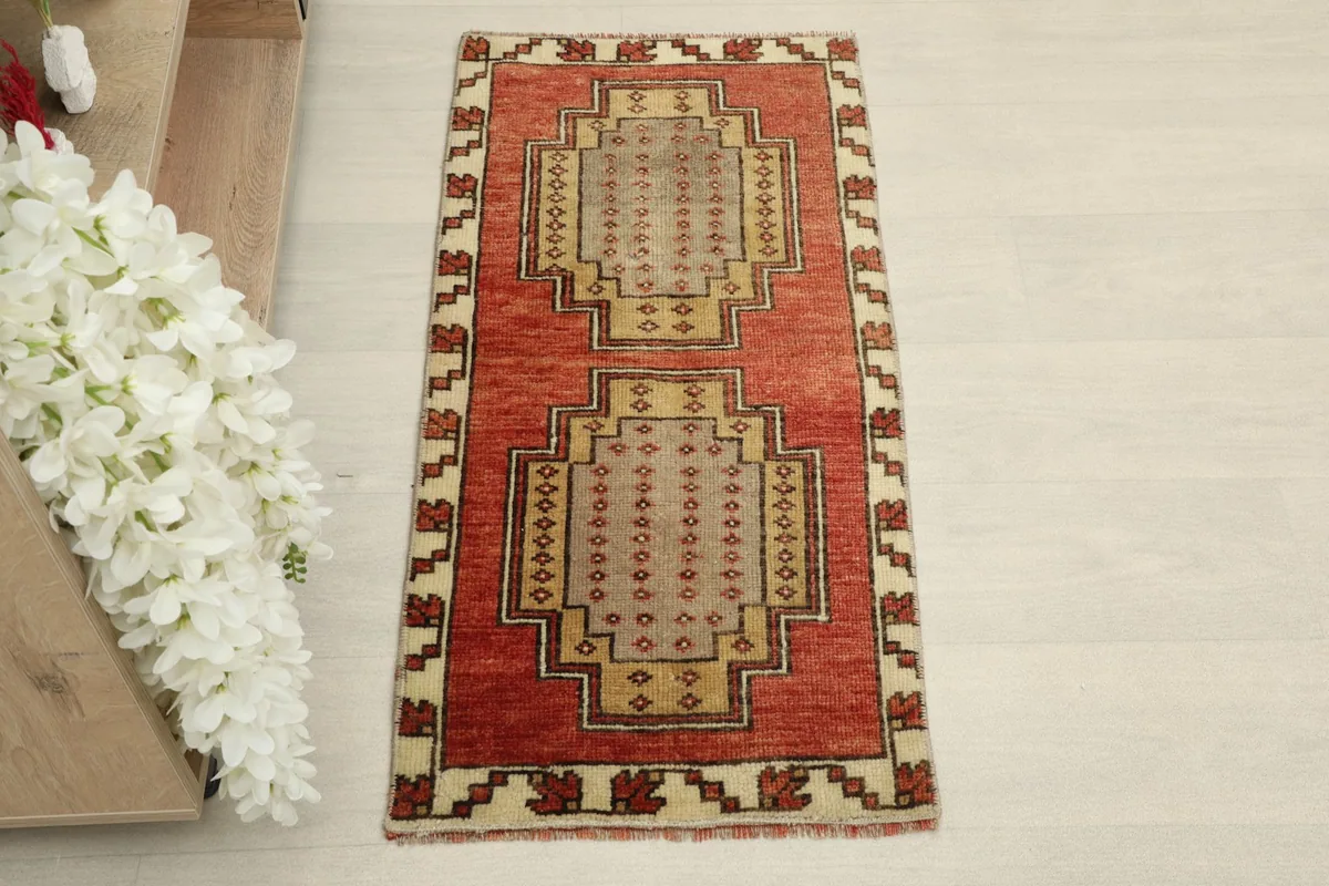 Overhead view of the red and beige geometric rug, showcasing its full pattern.