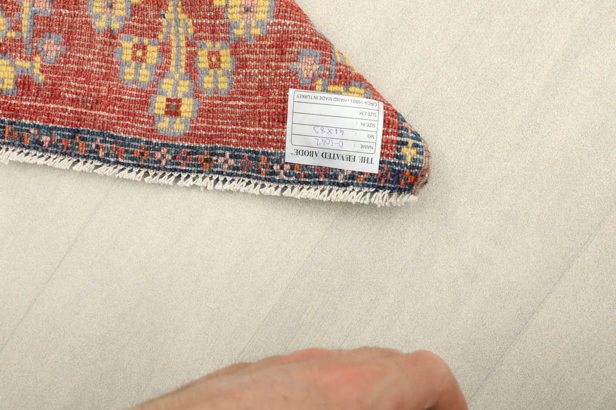 Close-up of the label on the back of the rug, confirming its hand-knotted vintage origin.