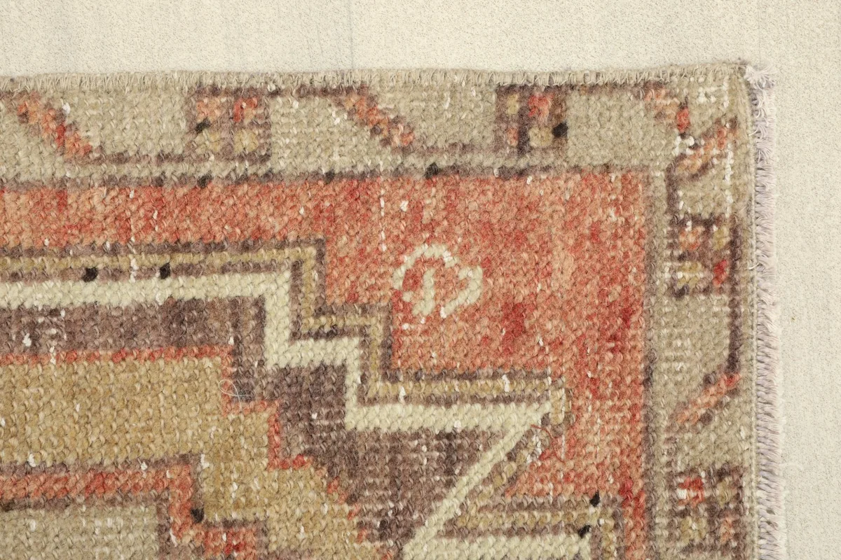 Detailed view of the orange and beige border with geometric shapes and soft fringe