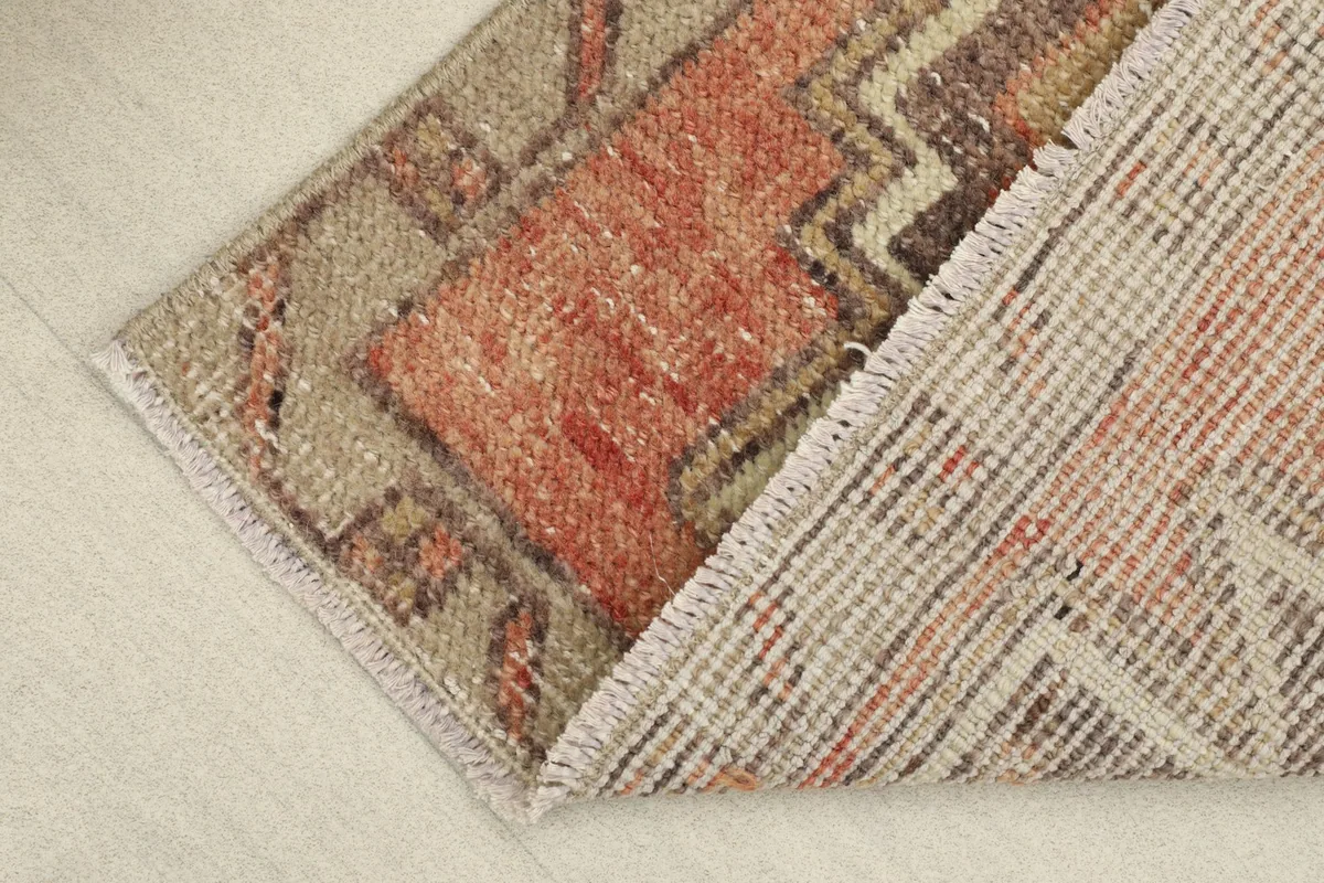 View of the rug's back and folded corner, revealing the hand-knotted cotton foundation