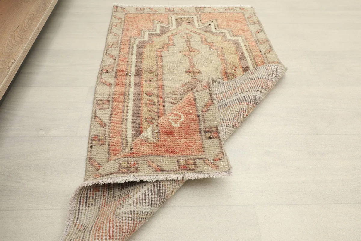 The rug partially folded, showing the flexibility and texture of the vintage wool pile