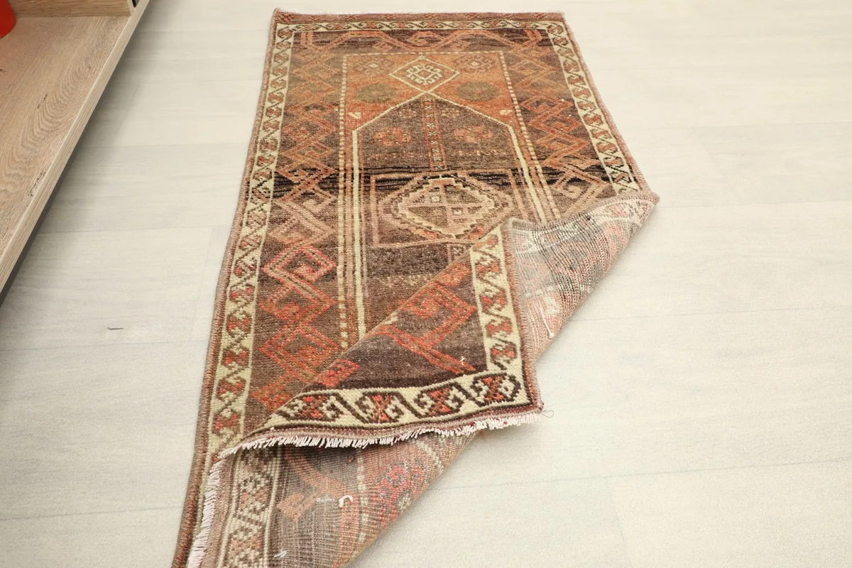 Overhead view of the rug partially folded, showing its size and a glimpse of a room setting