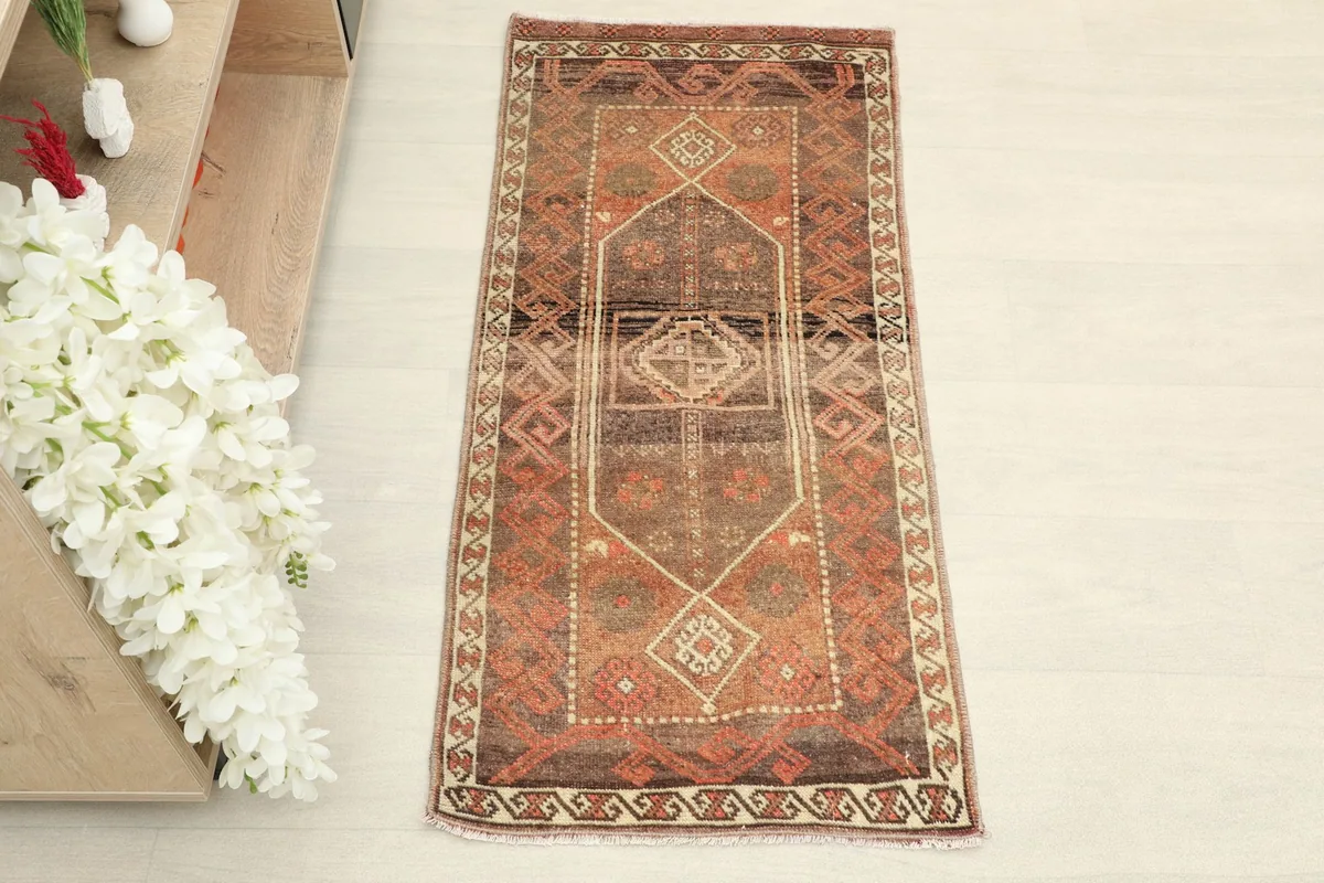 Full view of the doormat placed in a room setting, next to a shelf with books and flowers
