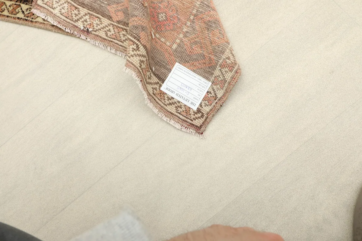 Close-up of the back of the rug, revealing the hand-knotted construction and a product tag