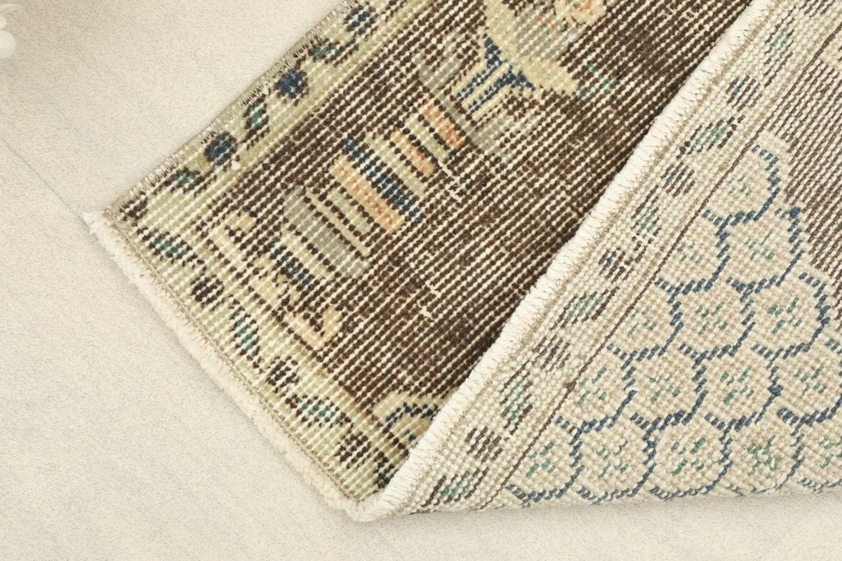 View of the back of the hand-knotted rug, revealing the cotton foundation and construction.