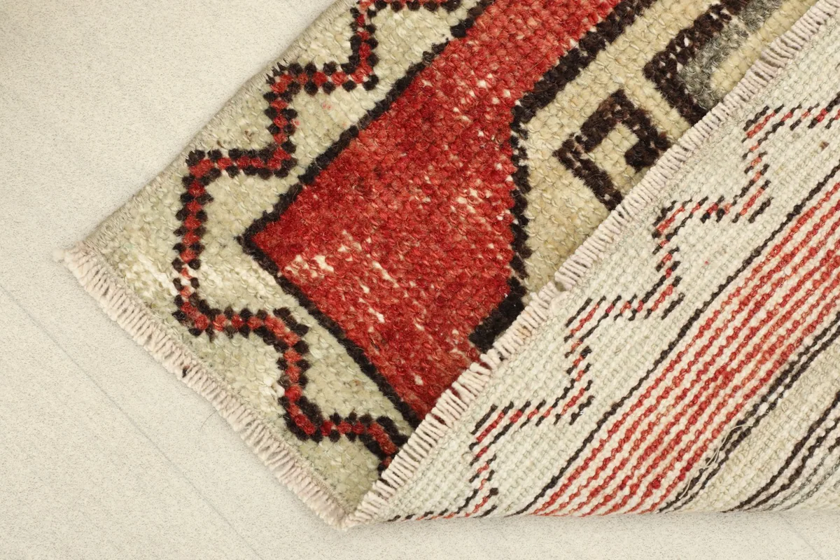 View of the rug's low pile and the back, showing the hand-knotted construction.