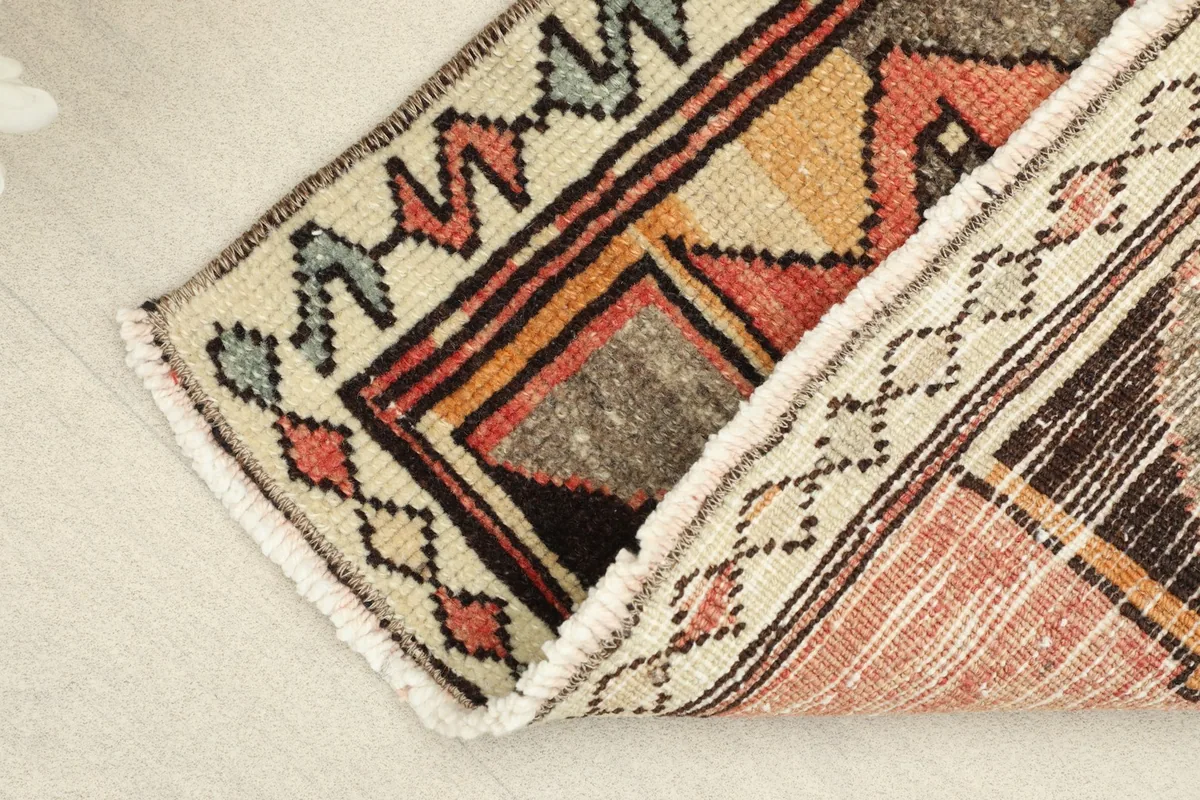 View showing the texture of the low wool pile and the reverse side of the hand-knotted rug.