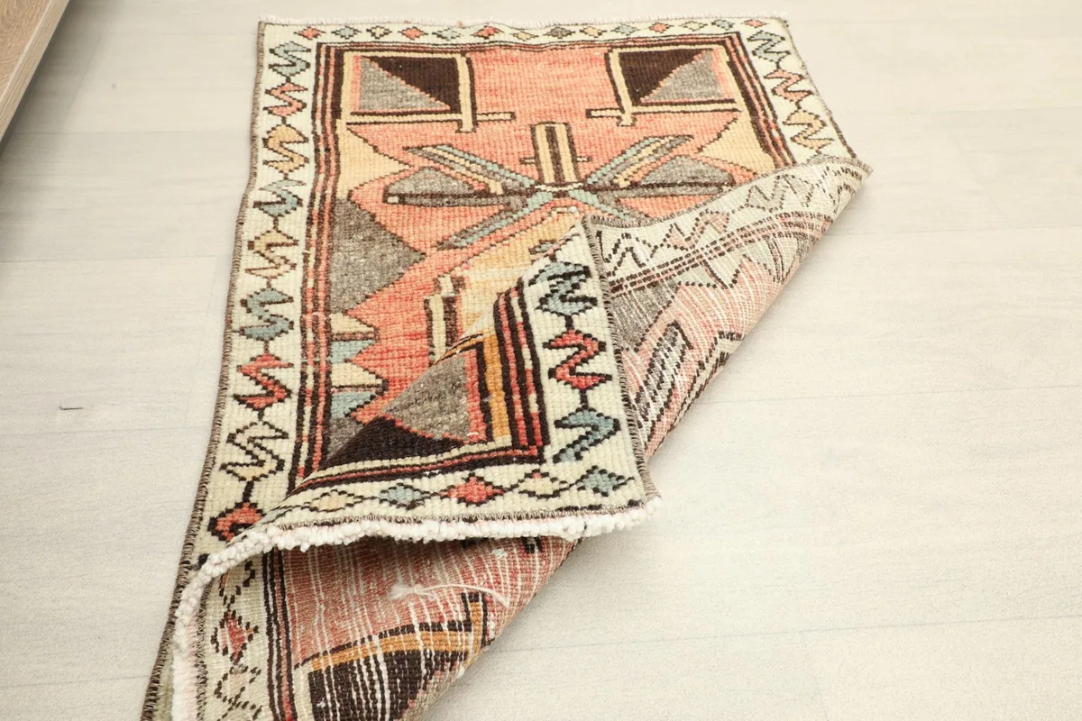 The vintage Anatolian rug partially folded, highlighting its flexibility and construction.