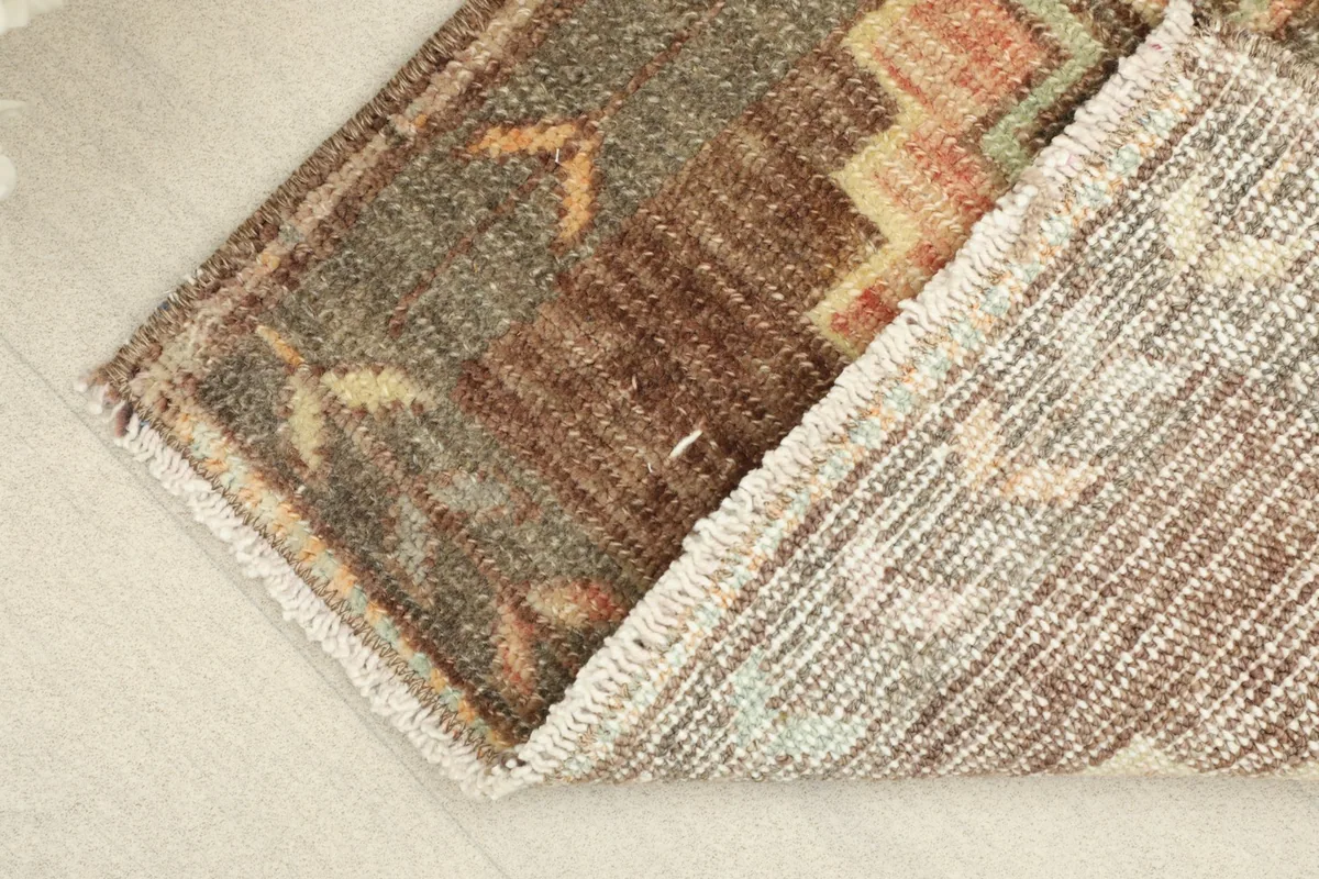 View of the low wool pile and a glimpse of the cotton foundation of the hand-knotted rug