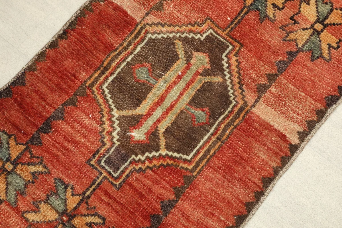 Angled view highlighting the central brown and tan geometric medallion and red field