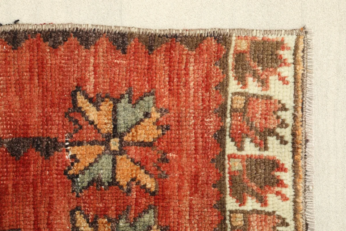 Close-up of the stylized green and yellow leaf-like motifs on the red field
