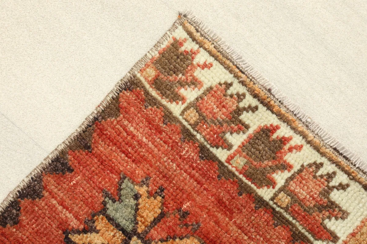 Corner detail showing the beige border with brown and red stylized motifs