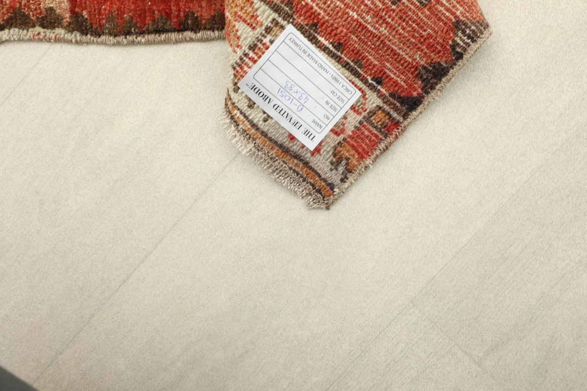 Close-up of the back of the rug, revealing the knotting and the care label