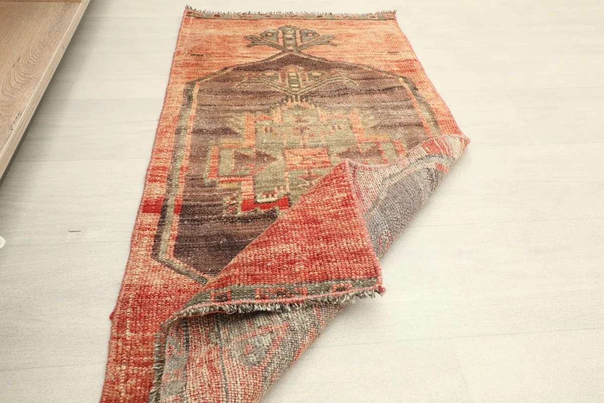 Angled view of the rug with a corner folded, showing the overall design and construction.