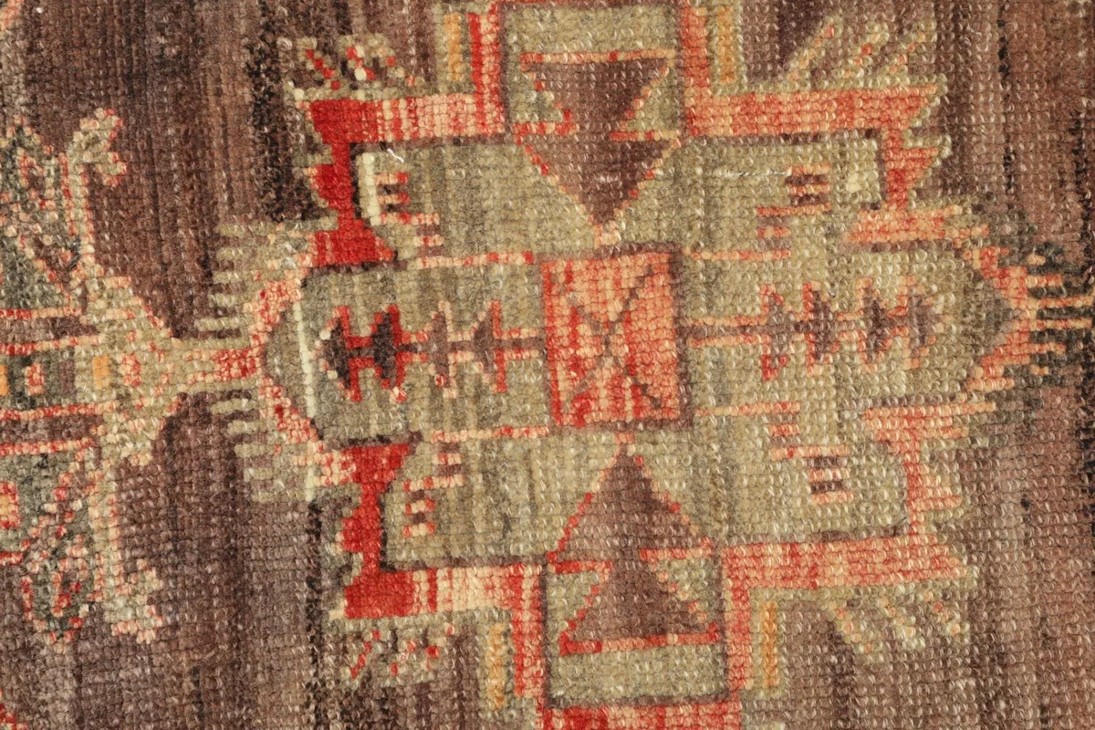 Detailed view of the hand-knotted wool pile and intricate geometric motifs within the medallion.