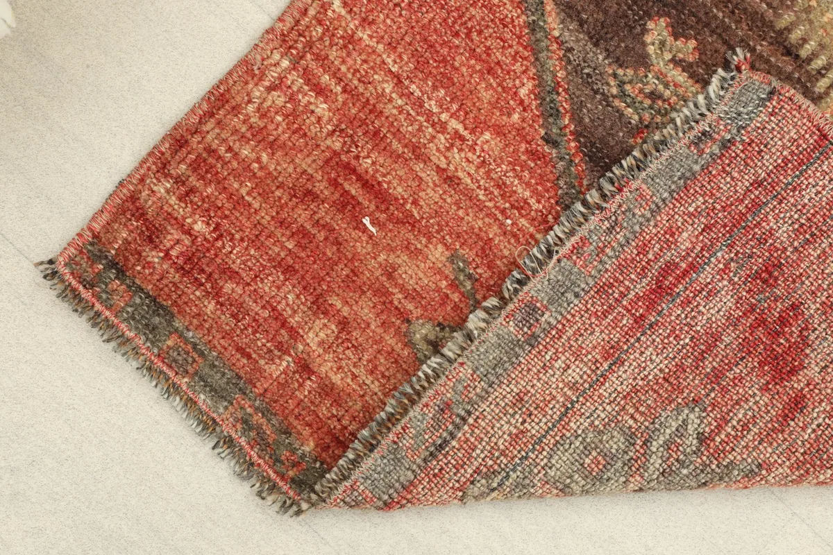 Folded corner revealing the back of the hand-knotted wool pile on cotton foundation.