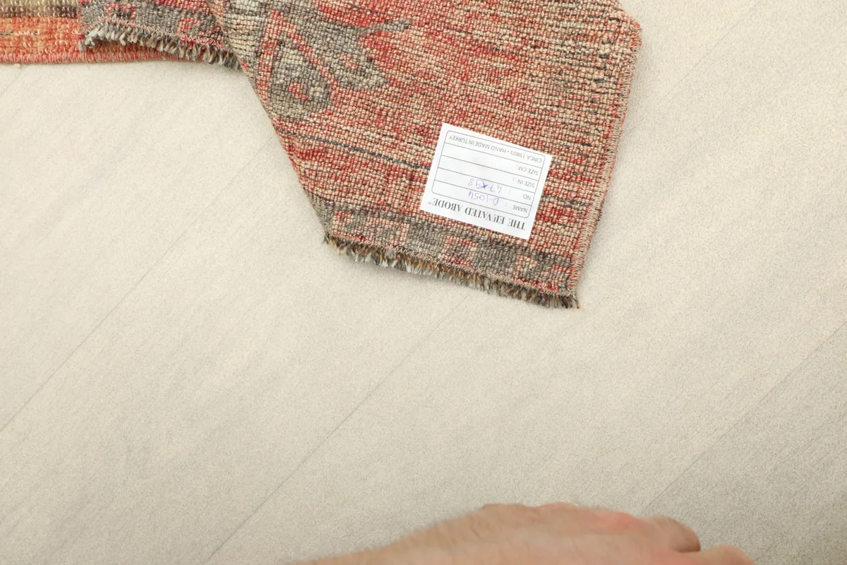 Close-up of the back of the rug, showing the knotting and a product label.