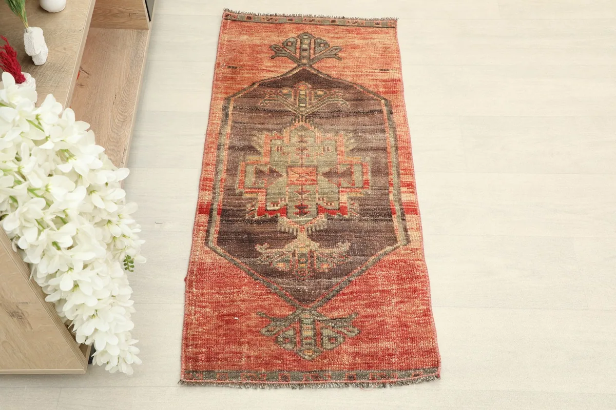 Overhead view showcasing the rust field and central brown and olive tribal medallion.